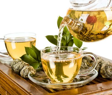 still life of the glass teapot flow green tea in cup on white background, isolated,  tea ceremony